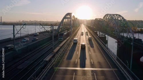 Aerial view car traffic on the bridge highway road. Bright evening sunset light reflecting on the road. photo