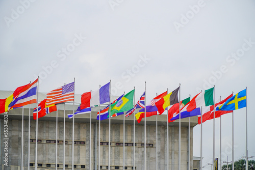 Flags of different countries on a tall flagpole in Thailand