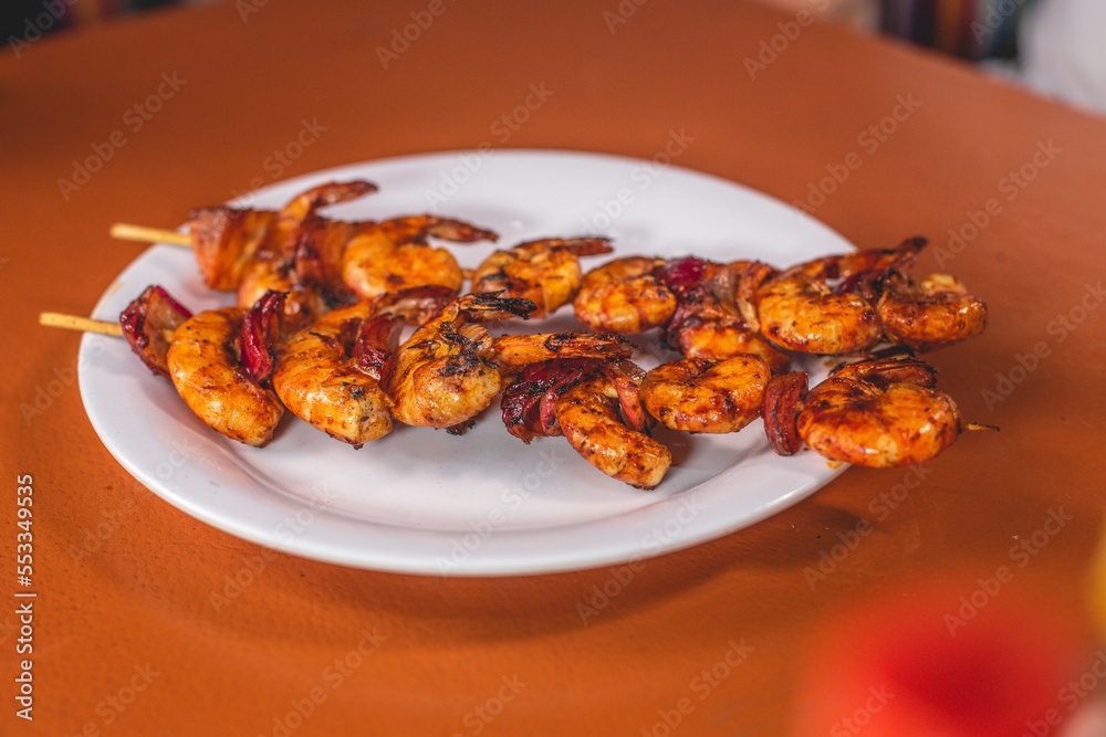Deliciosos camarones adobados a la plancha servidos en un plato Deliciosos camarones adobados a la plancha servidos en un plato