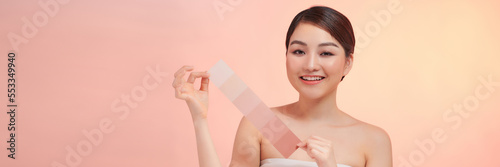 woman face with perfect skin choosing makeup foundation with skin tone palette.