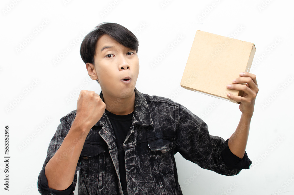 Happy Ecstatic Young Asian man Holding Package Parcel box isolated over white background. Delivery courier and shipping service concept Happy Ecstatic Young Asian man Holding Package Parcel box isolated over white background. Delivery courier and shipping service concept