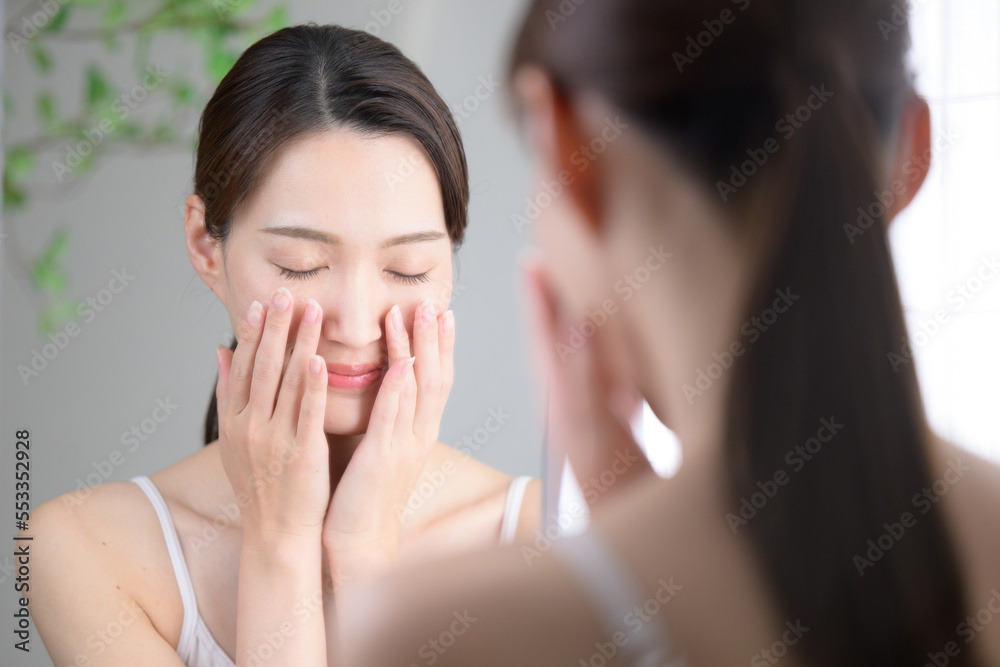 洗面台で洗顔や化粧水を塗る美しい女性 洗面台で洗顔や化粧水を塗る美しい女性