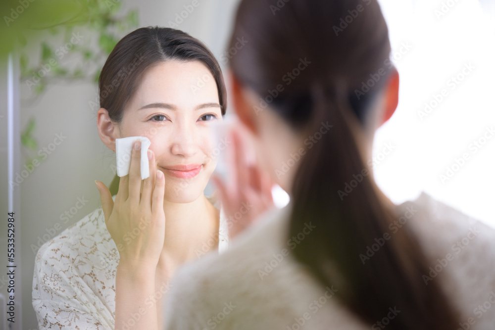 Beautiful woman applying lotion at the washbasin Beautiful woman applying lotion at the washbasin