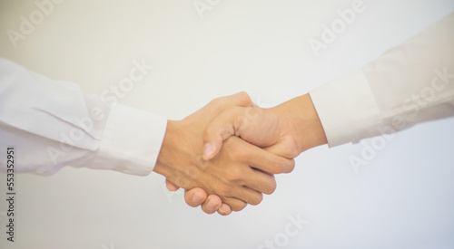 Close up of two businessmen shake hands after a business deal in the office.