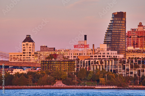 WELCOME sign on building of Brooklyn from coast with waters and buildings around during dusk light