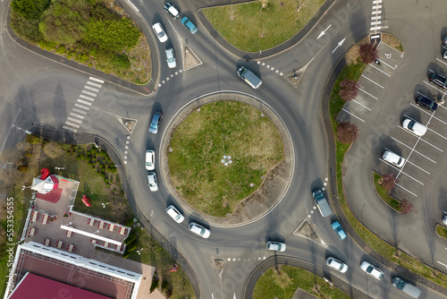Aerial view of road roundabout intersection with fast moving heavy traffic. Urban circular transportation crossroads