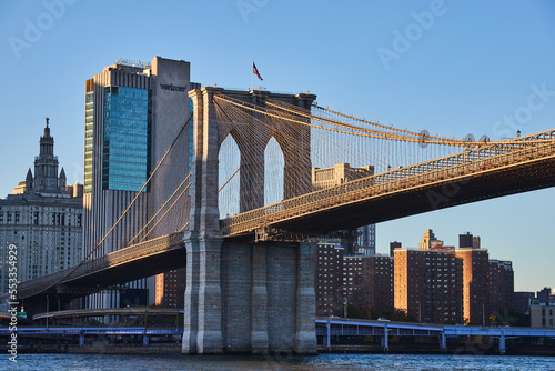 Stunning Brooklyn Bridge in New York City with skyline in background and American Flag
