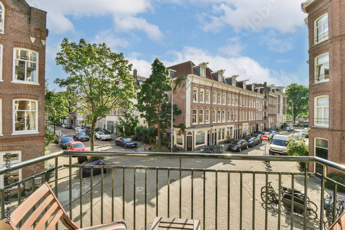 Panoramic view of brick buildings with parking and trees from narrowl balcony photo
