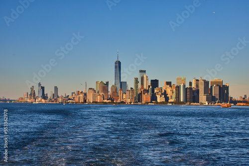 Stunning southern Manhattan island from ferry with soft golden light