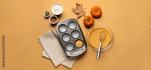 Preparing of tasty pumpkin muffins on color background, top view