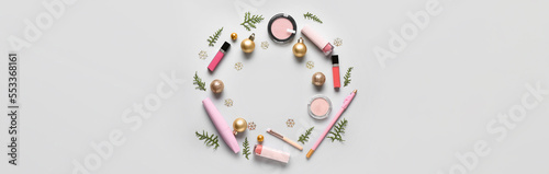 Frame made of makeup cosmetics with Christmas decor on light background