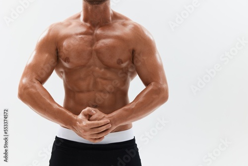 Man athletic body bodybuilder in briefs with naked torso abs full-length in the background, fitness classes. Advertising, sports, active lifestyle, competition, challenge concept.