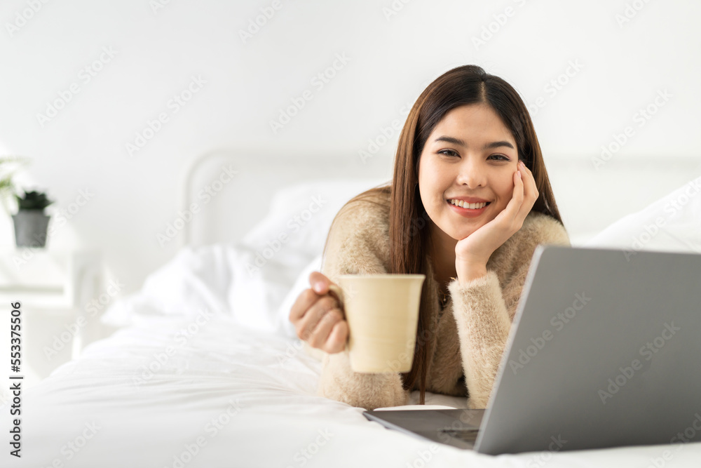 Portrait of smiling happy cheerful beauty pretty asian woman relaxing drinking and looking at cup of hot coffee or tea.Girl felling enjoy having breakfast in holiday morning vacation on bed at home Portrait of smiling happy cheerful beauty pretty asian woman relaxing drinking and looking at cup of hot coffee or tea.Girl felling enjoy having breakfast in holiday morning vacation on bed at home