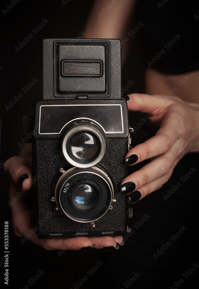 Woman hands hold retro photo camera close up