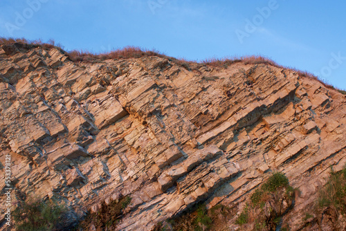 Rock textures. Geological layers of stone in the rock. Steep cliff break.