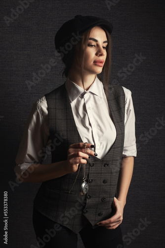  Young woman with retro watch studio shot on dark bg