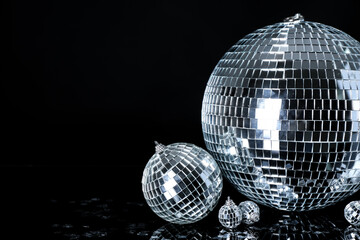 Disco ball with Christmas decor and confetti on black background