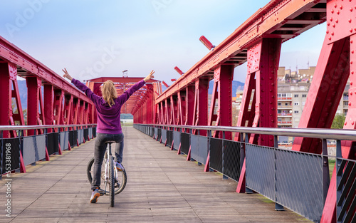Woman tourist enjoying bicycle on green way on the bridge of railway inTortosa, Tarragona province- Catalonia in Spain photo