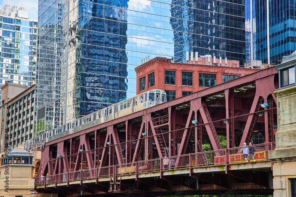 Fototapeta premium Travel train in Chicago going over bridge by skyscrapers