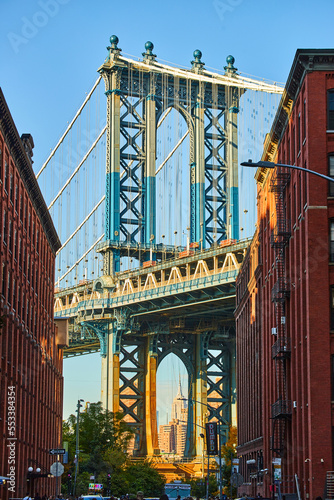 Sunny Manhattan Bridge from Brooklyn New York City between two brick buildings © Nicholas J. Klein