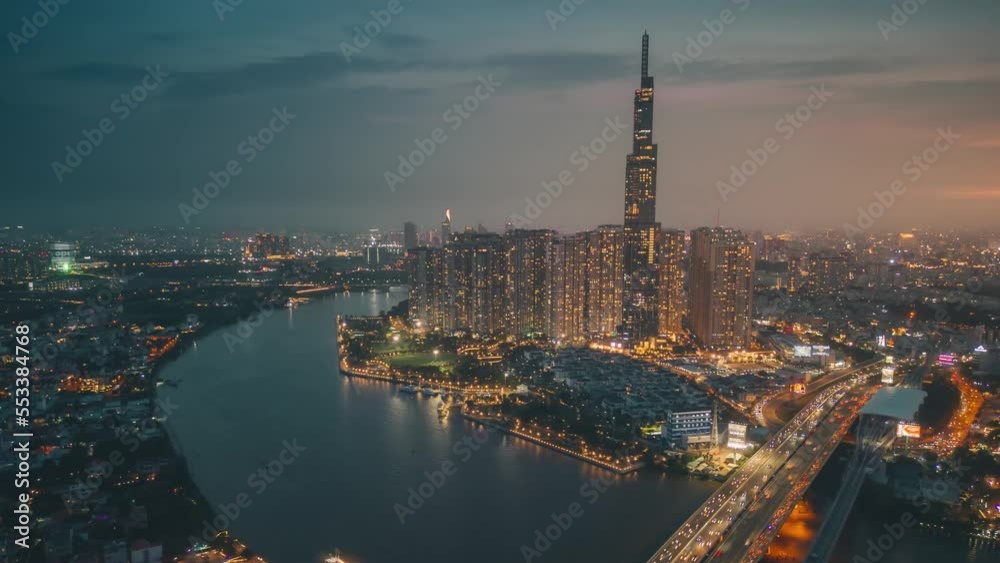 Aerial hyper lapse of Landmark 81 skyscraper and Ho Chi Minh city skyline in sunset to night and moving traffic on street. Landscape and business concept