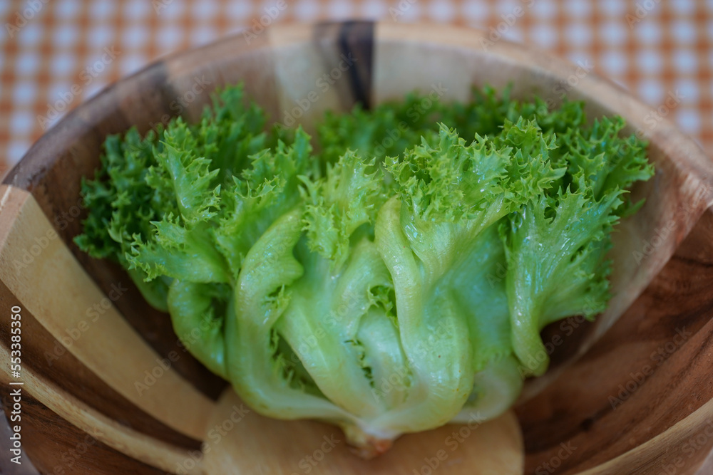 One of fresh salad green Fillet Iceberg on wooden salad bowl. One of fresh salad green Fillet Iceberg on wooden salad bowl.