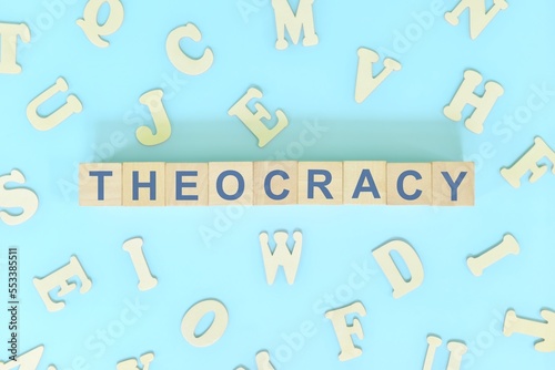 Theocracy government form concept. Wooden blocks typography flat lay in blue background.