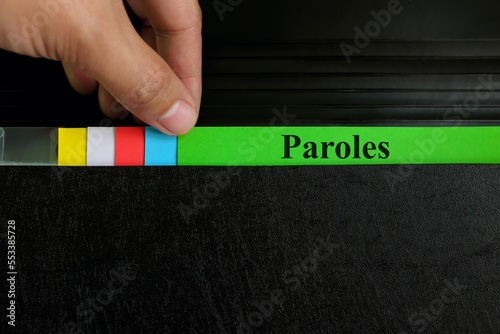 Hand picking parole file record in black binder folder. Paroles criminal law legal and justice concept.