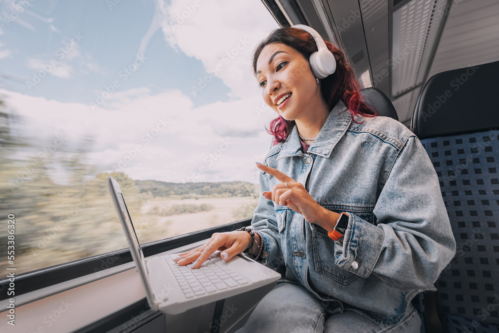 © EdNurg - Girl streamer or video blogger, having online remote meeting or teaching and learning language via wi-fi Internet on her laptop screen while traveling on a train