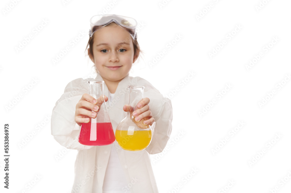Selective focus on lab flasks with chemical liquid substances, in hands of a blurred little girl, showing the current chemical reaction at chemistry lesson. Science. Early developments for smart kids Selective focus on lab flasks with chemical liquid substances, in hands of a blurred little girl, showing the current chemical reaction at chemistry lesson. Science. Early developments for smart kids