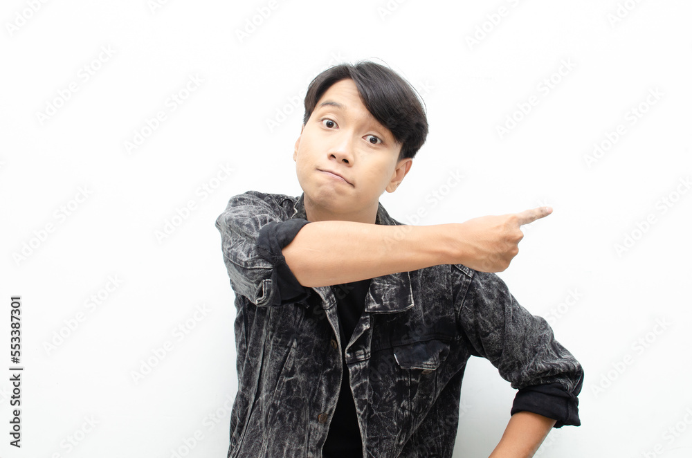 Happy Ecstatic asian man wear jeans jacket pointing finger to copy space presenting and showing goods. billboard model advertisment concept. man with wow face showing something. Happy Ecstatic asian man wear jeans jacket pointing finger to copy space presenting and showing goods. billboard model advertisment concept. man with wow face showing something.