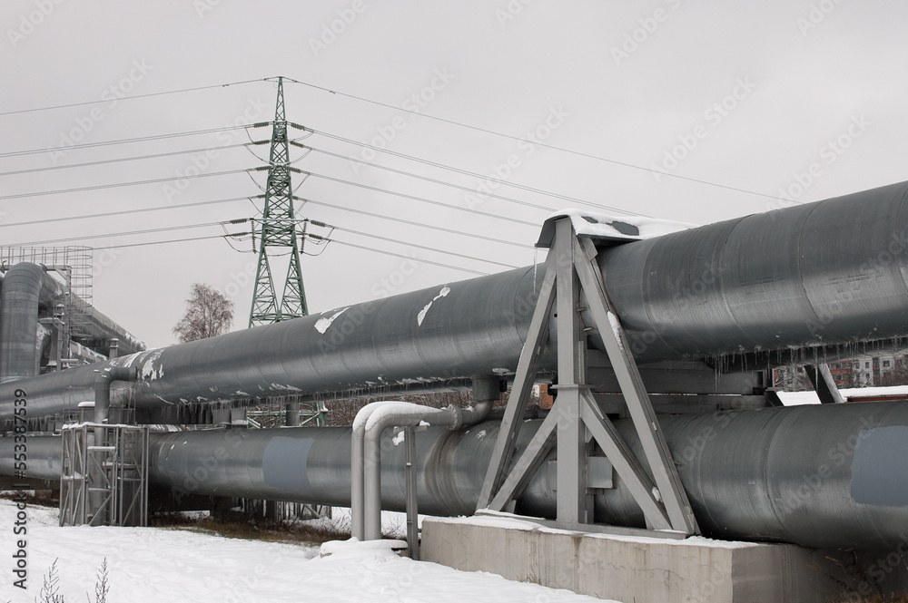 pipeline and power line in the city in winter against the gray sky. pipeline and power line in the city in winter against the gray sky.