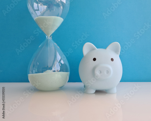 Blue piggy bank with an hourglass closeup