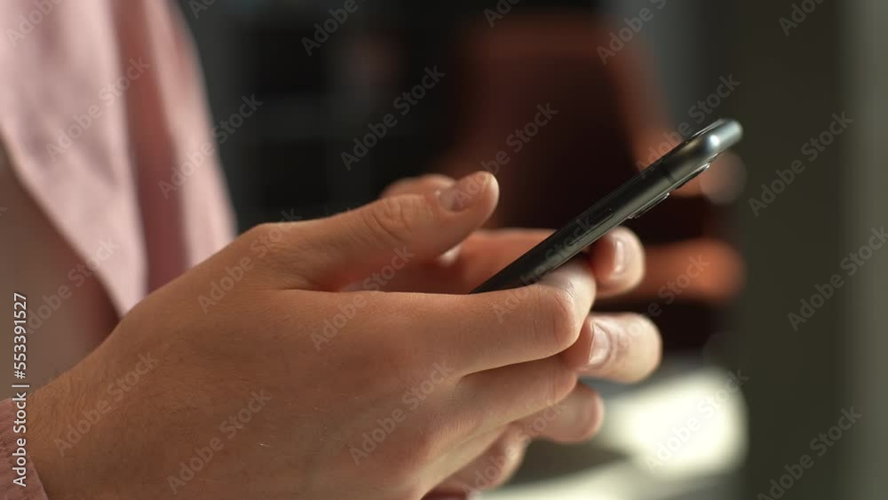 Close-up side view of hands unrecognizable man using mobile phone , doing swiping, scrolling gestures. Male making order of goods online using smartphone. Shooting in slow motion. Close-up side view of hands unrecognizable man using mobile phone , doing swiping, scrolling gestures. Male making order of goods online using smartphone. Shooting in slow motion.