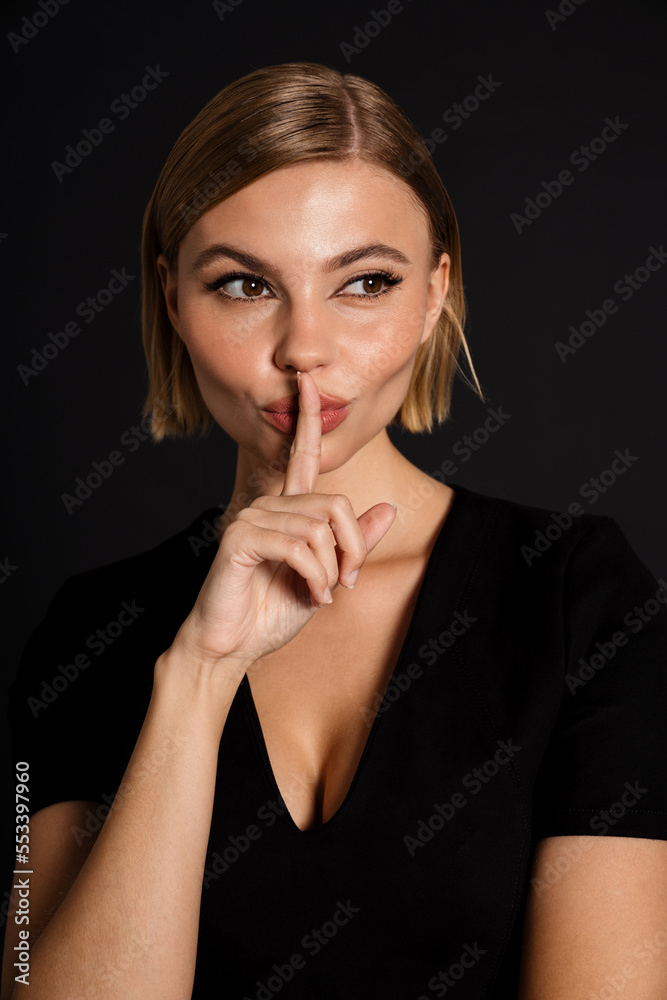 Young blond woman showing silence gesture at camera Young blond woman showing silence gesture at camera