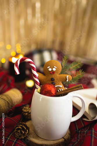 A little ginger man in a mug with cocoa. Christmas and New Year flatlay. Winter mood. A mug with a drink, Christmas toys and decorations and gingerbread cookies. A close-up of a winter flatlay.