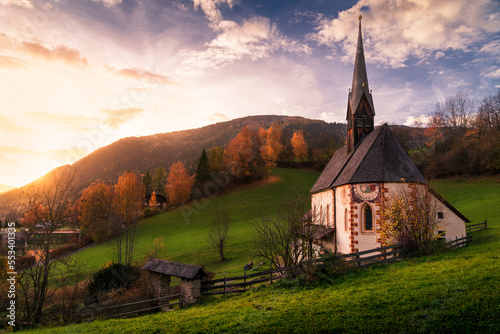 Landscape view at sunset in autumn of the Bad Kleinkirchheim countryside valley, Austrian alps, with the St. Katharina im Bade (St. Kathrein) church on the foreground