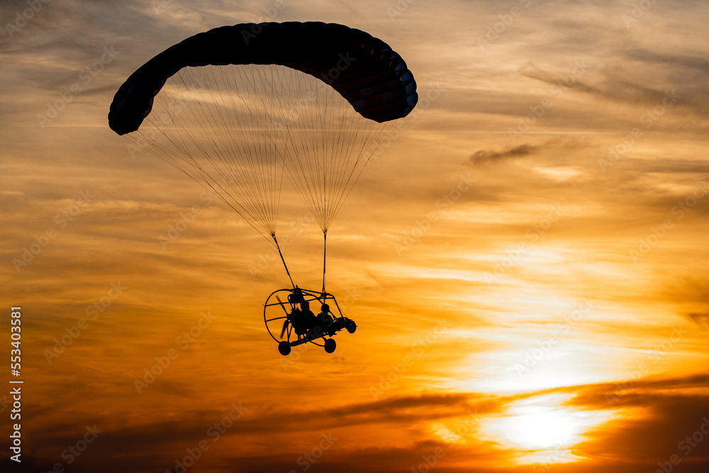 Powered paraglider in sunset - obrazy, fototapety, plakaty 