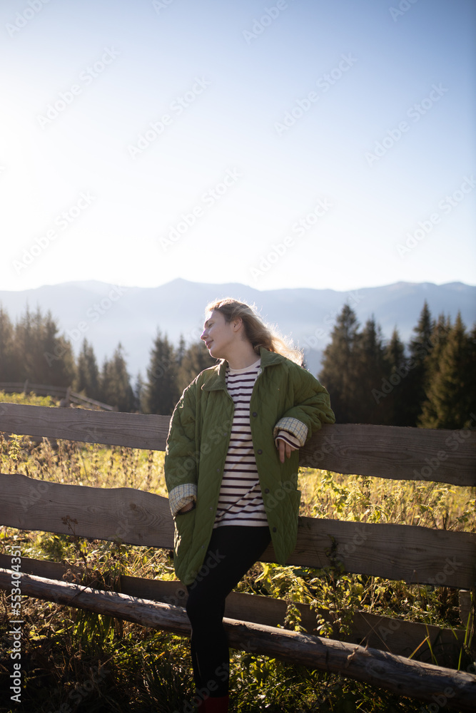 The girl enjoys a vacation in the mountains. Rest and relaxation outside the city. Mountain trip.