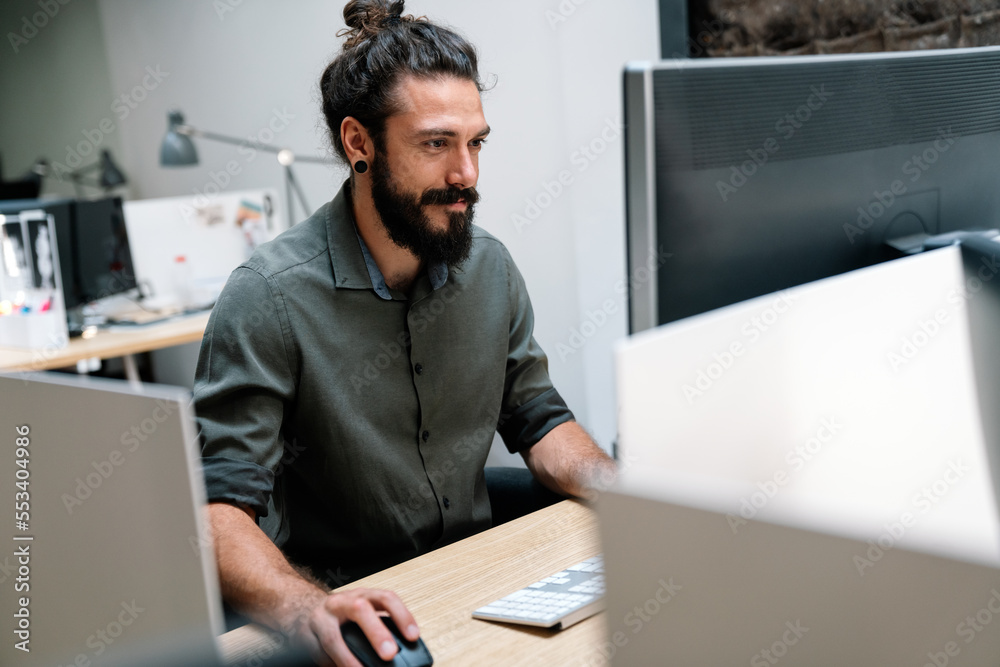 Concentrated young business man employee worker analyzing online sales statistics data on computer Concentrated young business man employee worker analyzing online sales statistics data on computer