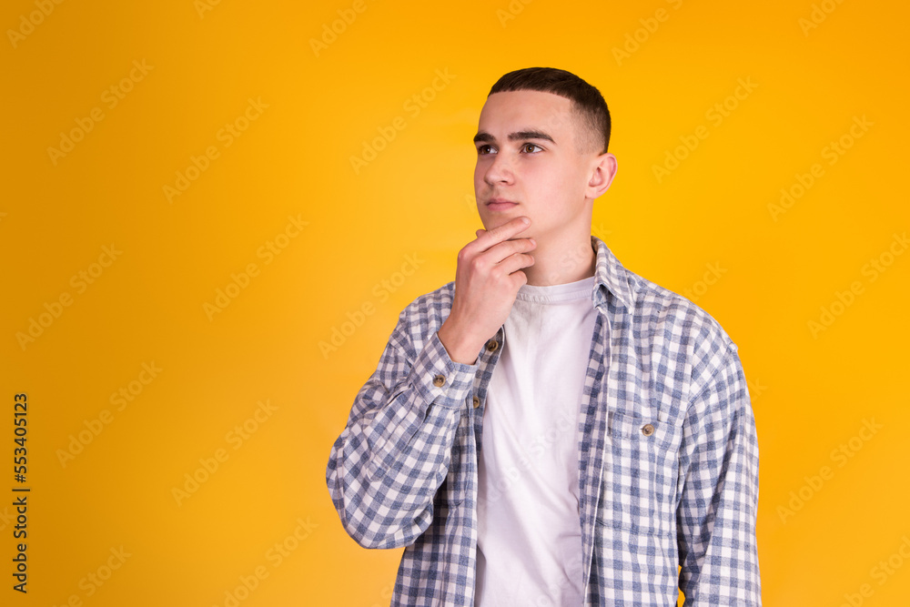 A handsome guy in a checkered shirt on a yellow background A handsome guy in a checkered shirt on a yellow background