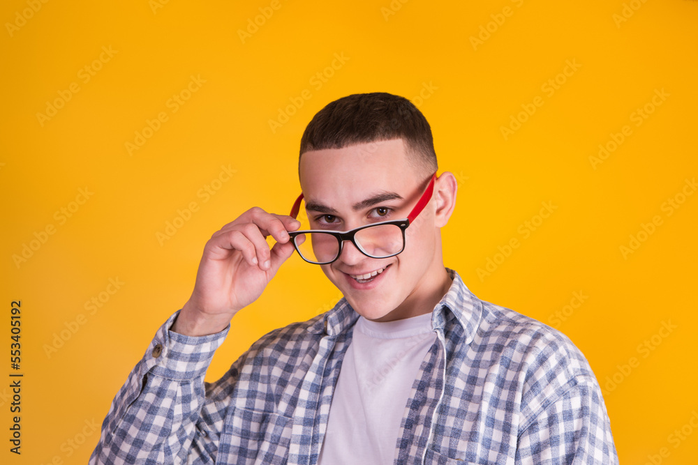 A handsome guy in a checkered shirt on a yellow background A handsome guy in a checkered shirt on a yellow background