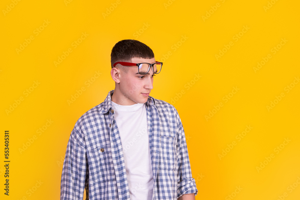 A handsome guy in a checkered shirt on a yellow background A handsome guy in a checkered shirt on a yellow background