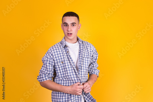 A handsome guy in a checkered shirt on a yellow background