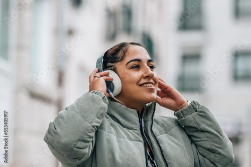 happy girl with headphones on the street