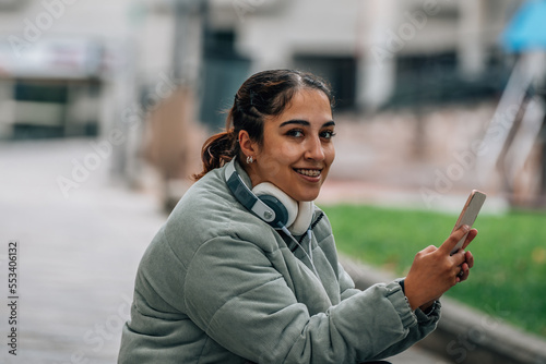 girl with headphones and mobile phone on the street
