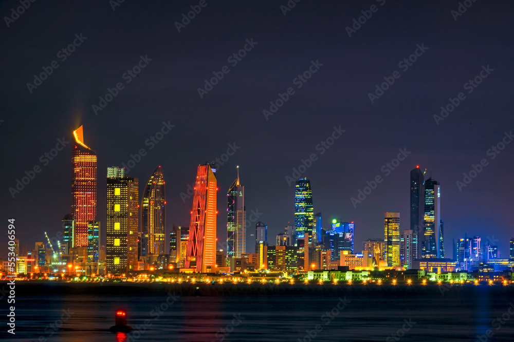 View of the Kuwait skyline - with the best known landmark of Kuwait City - during Night. Kuwait City buildings and skyline from beach at night..