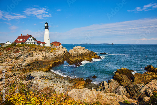 Bay with rocky coasts in Maine with overlooking white lighthouse