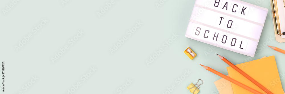 Back to school. Banner with lightbox with letters and stationery on a blue pastel background. Place for text. Back to school. Banner with lightbox with letters and stationery on a blue pastel background. Place for text.