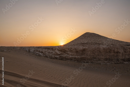 Sun is rising in the desert . Sunrise-sunset desert landscape photo. Gulf desert sunrise with sand dunes and sand pattern visible with sun shine.